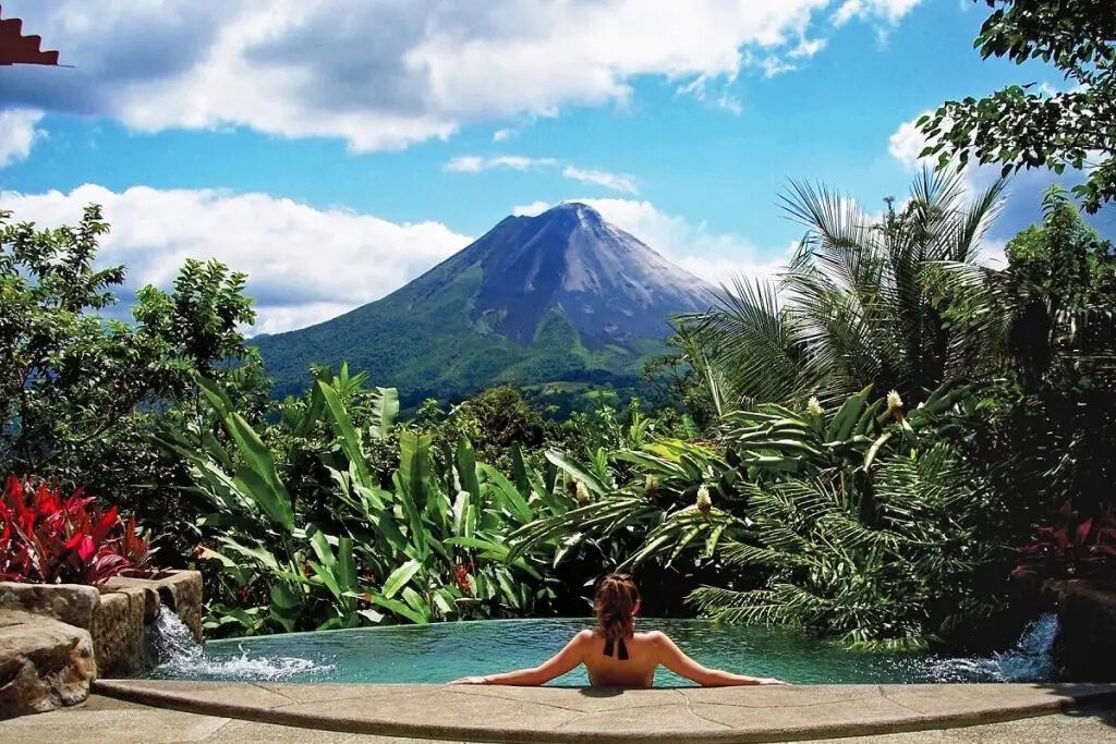 Woman relaxing in pool with mountain view